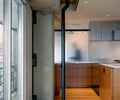 Preview of Market Condo - Image 5: Apartment, Housing, Indoors, Interior Design, structure concrete, exposed steel, wood floor, stainless steel cabinets, tab pulls, glass rolling door, etched glass, Condominium, Concrete, Wood, Kitchen, Glass Door, Glass.