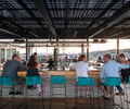 Preview of Mbar - Image 16: Person, Furniture, Restaurant, Wood, Steel, Concrete, Pergola, Structure Steel, Rooftop, Bar, Dining Table, Glass, Window.