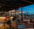 Preview of Mbar - Image 8: Human, Person, Wood, Steel, Structure Steel, Pergola, Outdoor, Rooftop, Bar, Dining Table, Window, Glass, Concrete.