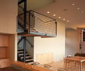 Preview of Mile Post 9 - Image 7: Dining Table, Furniture, Table, Banister, Handrail, Staircase, Indoors, steel stair, treads, wood floor, cabinetry, structure steel, kitchen.