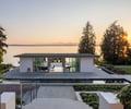 Preview of Northwest Reflections - Image 2: Roland Terry, modern architecture, glass doors, flat roof, green roof, concrete path, concrete stairs, railing, open layout, glass facade, landscaped garden, minimal design, waterfront, natural lighting, outdoor space, symmetrical design, reflective surfaces, panoramic view.