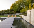 Preview of Northwest Reflections - Image 6: concrete wall, concrete floor, deck, landscape design, outdoor seating, water feature, garden, modern architecture, retaining wall, patio, greenery, lounge chairs, minimalistic, hardscape, sun loungers, outdoor lighting.