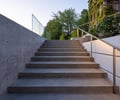 Preview of Northwest Reflections - Image 8: stairs, railing, concrete steps, concrete wall, outdoor staircase, glass railing, modern design, minimalist, landscaping, natural light, vegetation, exterior, architecture, contemporary, urban design.