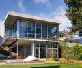 Preview of Open House - Image 21: Cantilever, Steel frame, Urban, Porch, Housing, House, garage door, glass exterior, outdoor eating, art, grass, cement board siding.