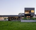 Preview of Seward Park Residence - Image 0: modern architecture, cantilever, concrete wall, large windows, dark facade, flat roof, outdoor patio, landscaping, structure steel, grassy lawn, residential building, horizontal lines, minimalist design, geometric shapes, open space, metal cladding.