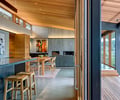 Preview of South Whidbey Residence - Image 15: Bar Stool, Furniture, Dining Table, Indoors, Interior Design, Wood, Glass, Window, Deck, Patio, Indoor Outdoor, Kitchen, Dining Room, sliding door, interior glass, exterior glass, Concrete floor, fireplace.