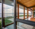Preview of South Whidbey Residence - Image 16: Housing, Window, Glass, Wood, Concrete, Indoor Outdoor, Deck, Waterfront, Exterior glass, Wood ceiling, Concrete floor, Steel framing, Wood framing, structure wood.