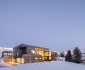 Preview of Sun Valley Fireweed - Image 4: modern architecture, corten, large windows, flat roof, outdoor lighting, winter setting, snow landscape, glass facade, minimalist design, geometric shapes, cantilever, two-story house, wood accents, steel materials, contemporary home.
