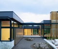 Preview of Sun Valley Fireweed - Image 10: modern architecture, corten steel, large windows, flat roof, minimal design, outdoor seating, glass facade, cantilever, landscaping, industrial look, metal cladding, concrete base, seamless indoor-outdoor transition, open courtyard, clean lines.