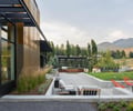 Preview of Sun Valley Fireweed - Image 12: modern architecture, outdoor space, corten, steel framing, glass facade, concrete wall, concrete floor, patio, garden landscaping, outdoor seating, fire pit, mountain view, pergola, wood paneling, minimalist design, greenery, natural light, exterior design, sustainability, contemporary style.