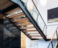 Preview of Sun Valley Fireweed - Image 15: stair, glass railing, open riser, steel structure, wood treads, modern design, minimalistic, pendant light, glass wall, interior architecture, contemporary, residential staircase, floating stairs, concrete floor, railing, structure steel.