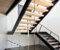 Preview of Sun Valley Fireweed - Image 17: stair, railing, glass railing, open risers, steel beams, wood steps, modern design, interior staircase, cantilever, structure wood, structure steel, concrete floor, minimalistic design, natural light, exposed wood, industrial style.
