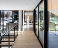Preview of Sun Valley Fireweed - Image 18: glass wall, large windows, wood floor, railing, open space, natural light, corridor, modern design, metal accents, cantilever, contemporary architecture, interior, exterior view, corten, landscape integration.