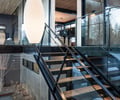 Preview of Sun Valley Fireweed - Image 19: stair, glass railing, concrete wall, wood ceiling, modern design, large windows, pendant lighting, open space, metal framing, interior architecture, wooden steps, natural light, structure wood, structure concrete, contemporary style, indoor-outdoor connection.