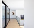 Preview of Sun Valley Fireweed - Image 20: glass railing, sliding glass doors, natural light, modern design, hallway, wooden floor, white walls, minimalistic, interior design, open space, recessed lighting, contemporary art, metal frame, clean lines.