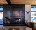 Preview of Sun Valley Fireweed - Image 21: ```plaintext
modern design, open space, large windows, natural light, wood ceiling, metal fireplace, indoor-outdoor connection, cozy seating, art display, living room, decorative sculpture, black frame, contemporary interior, glass wall, panoramic view, minimalistic decor, rustic elements, cantilever
```.
