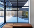 Preview of Sun Valley Fireweed - Image 23: glass wall, large windows, natural light, metal frame, wood ceiling, concrete floor, modern architecture, minimalist design, interior seating, outdoor view, corten steel, cantilever, clean lines, structure concrete, structure wood.