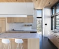 Preview of Sun Valley Fireweed - Image 29: kitchen, marble countertop, wood cabinets, modern design, concrete floor, pendant lighting, large windows, natural light, minimalistic, wooden ceiling, open layout, integrated appliances, white color scheme, island seating, sleek fixtures.