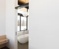 Preview of Sun Valley Fireweed - Image 32: bathroom, freestanding tub, sliding door, large windows, natural light, wood ceiling, white walls, pendant light, vanity, concrete floor, modern design, minimalist, open space, neutral colors, architectural lighting, clean lines.
