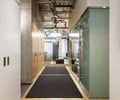 Preview of Undead Labs - Image 22: plywood flooring, exposed ceiling, ductwork, track lighting, modern, hallway, office, glass partition, exit sign, wood, concrete wall, structure concrete.