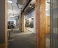 Preview of Undead Labs - Image 0: open floor plan, industrial aesthetic, exposed ceiling, mixed materials, wood beams, column, metal mesh partition, office space, carpet flooring, interior lighting, glass walls, conduit on ceiling, structure wood.