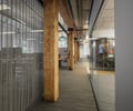 Preview of Undead Labs - Image 1: open floor plan, wood beam, concrete floor, glass partition, metal mesh, natural light, textured glass, transparent office, structure wood, carpet flooring, modern interior, indoor lighting, corridor.