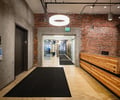 Preview of Undead Labs - Image 20: exposed brick, concrete wall, structural concrete, wood bench, office, modern lighting, adaptive reuse, open space, industrial style, corridor, railing, color.
