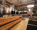 Preview of Undead Labs - Image 8: open floor plan, office, wood paneling, exposed ceiling, industrial style, ambient lighting, pendant light fixtures, glass partition, mural, nature theme, brick wall, concrete floor, structure wood, color.