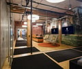 Preview of Undead Labs - Image 19: open floor plan, office space, glass partition, exposed brick, track lighting, pendant lights, color, modern furniture, wood ceiling beams, polished concrete floor, structure wood, commercial design, interior branding, corridor.