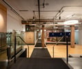 Preview of Undead Labs - Image 13: open floor plan, wood beams, concrete floor, exposed ductwork, modern lighting, glass partition, neutral color palette, railing.