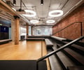 Preview of Undead Labs - Image 4: exposed brick, industrial style, open floor plan, modern lighting, stair, railing, concrete floor, wood, steel beam, large windows, mixed materials, interior design, office space, reflective ceiling panels.