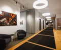 Preview of Undead Labs - Image 7: modern, office, corridor, exposed brick, concrete wall, wood flooring, pendant lighting, recessed lighting, artwork, texture contrast, neutral color palette, black furniture, open space.