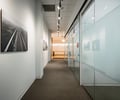 Preview of Undead Labs - Image 6: corridor, track lighting, frosted glass, glass door, pivot door, carpet flooring, interior, wall art, modern design, office space, neutral color palette.