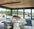 Preview of West Newton Penthouse - Image 2: Great room, Chair, Furniture, Dining Table, Table, Dining Room, Indoors, Room, Door, Sliding Door, Carpet, Home Decor, wood ceiling, lighting, concrete floor, fireplace, pavers, water feature.