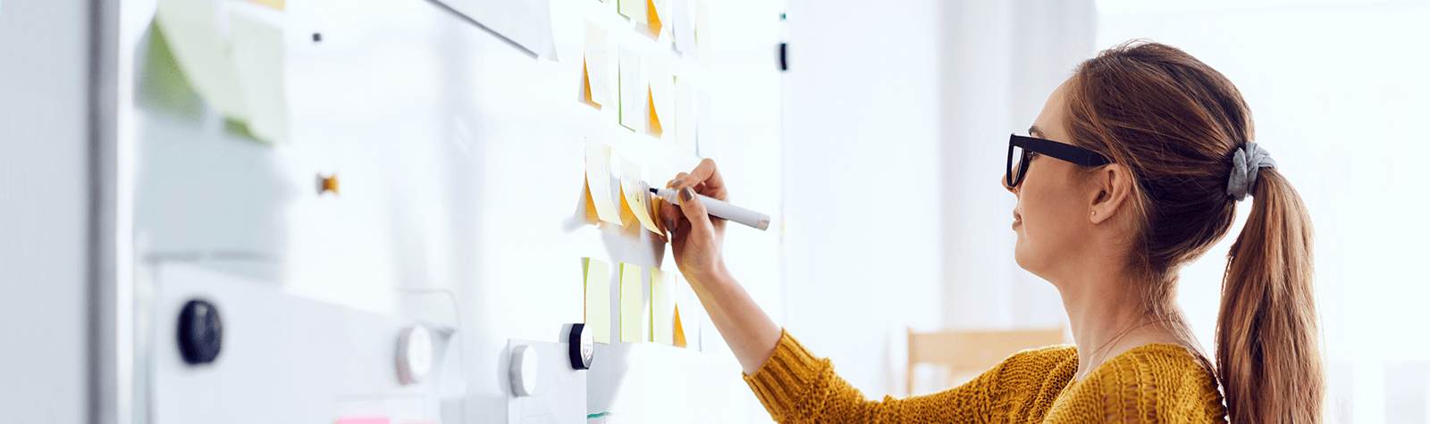 Woman at White Board planning and prioritizing.