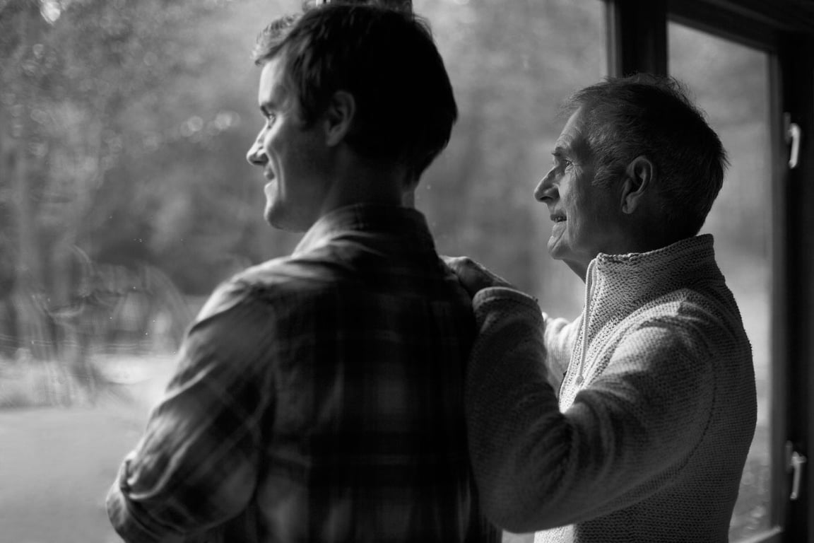 Father and son looking out window