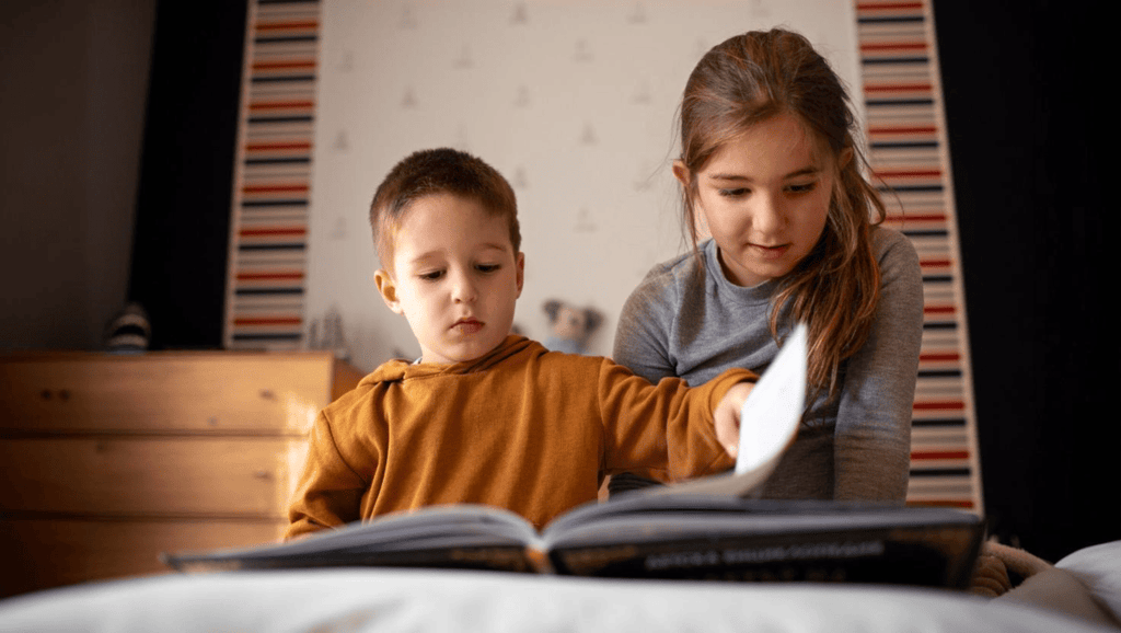 irmaos lendo livro no quarto