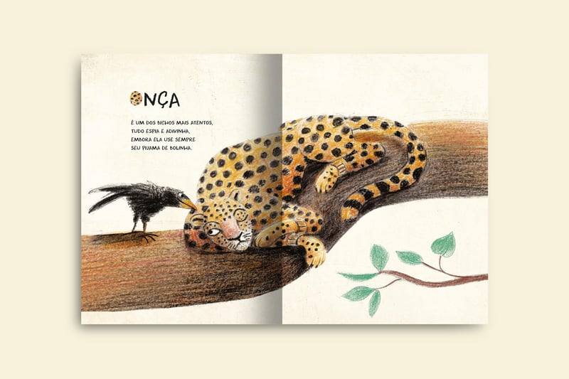 onca pintada deitada em cima de uma arvore espiando um corvo que esta bem pertinho dela livro na passarela do mundo colecao brasilidades