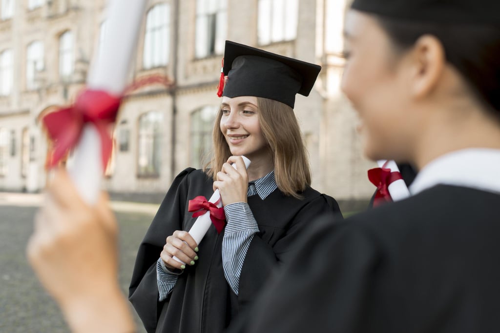 Estudante segurando seu diploma em destaque, com o fundo desfocado de uma plateia em um ambiente de formatura.