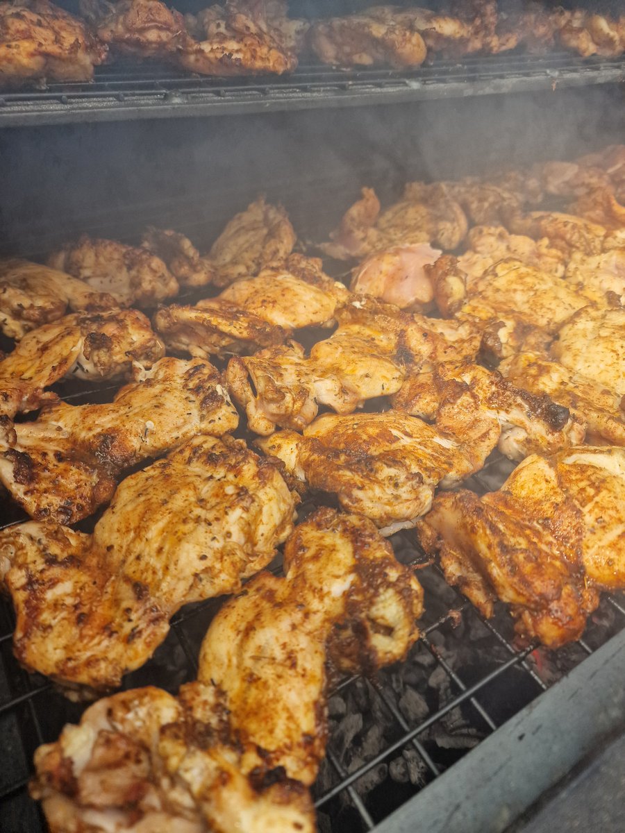 Succulent chicken pieces with crispy skin cooking on a BBQ grill, ready to be served at an event