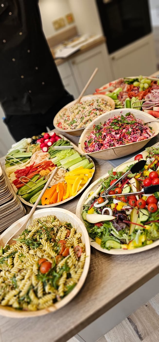 A vibrant buffet spread featuring fresh salads, pasta, and crudités, perfect for any event