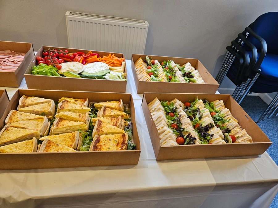 A selection of freshly prepared sandwiches, quiches, and crudités with dips, perfect for a corporate lunch or event buffet