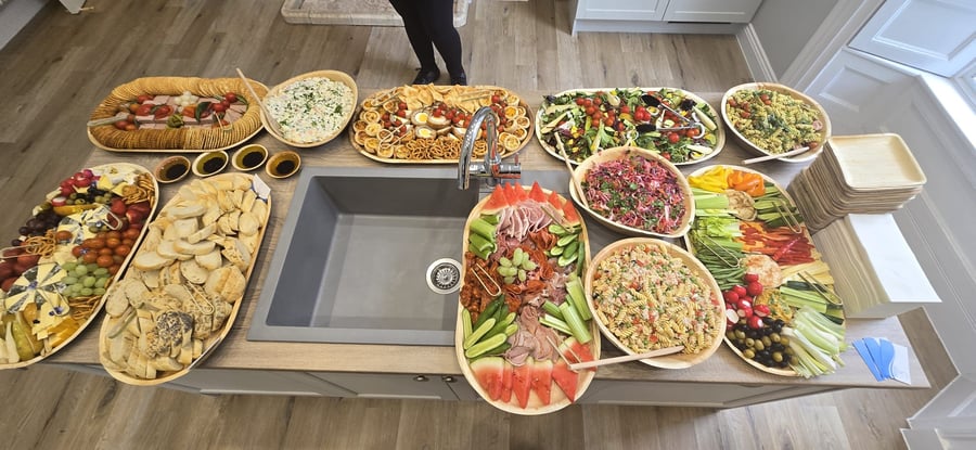 An impressive buffet spread with charcuterie, cheeses, salads, and fresh bread, perfect for any event