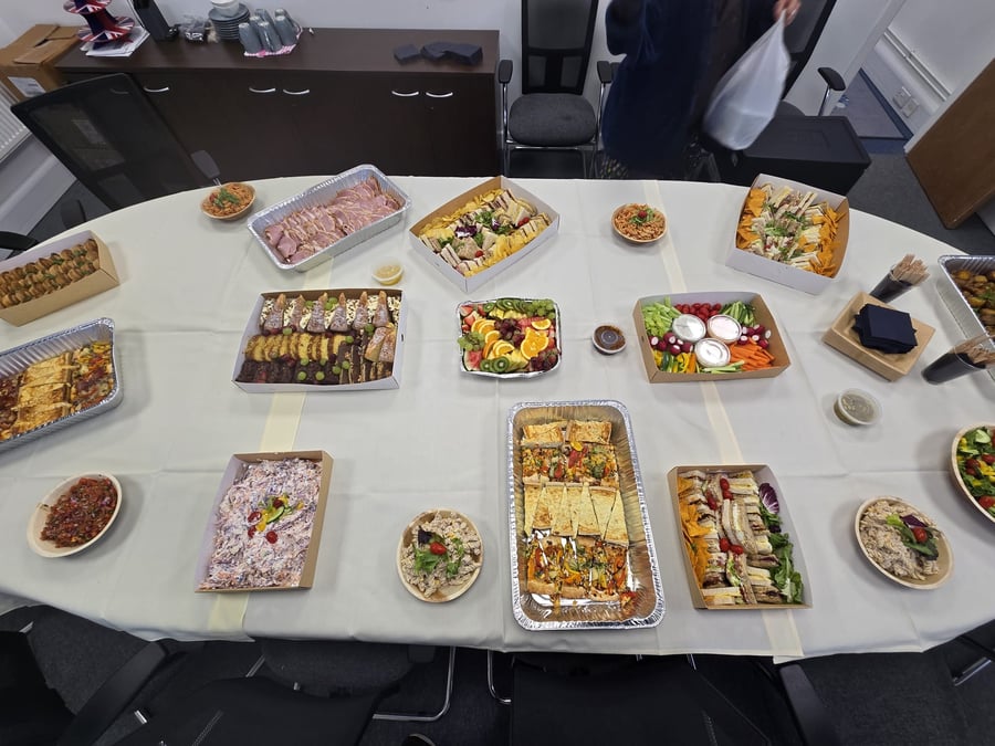 A varied buffet spread featuring sandwiches, salads, fruit, and crudités, ideal for a corporate or event lunch