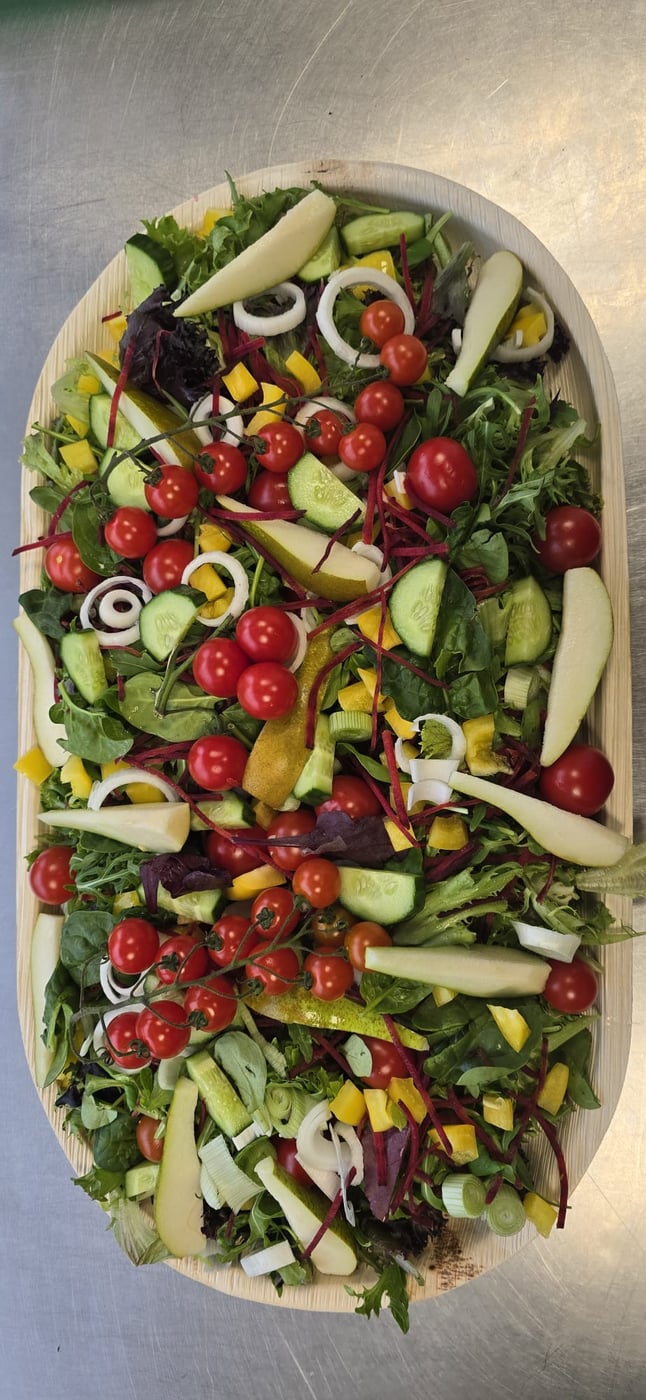 A vibrant mixed salad with cherry tomatoes, cucumber, peppers, and onion, perfect for a buffet spread