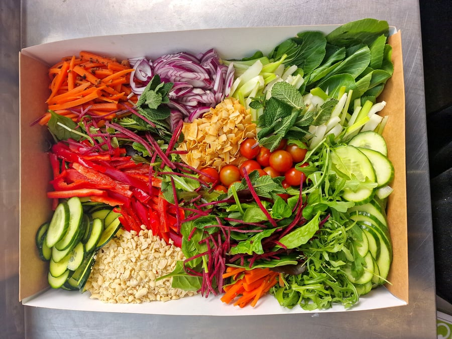 A vibrant and fresh salad box filled with colourful chopped vegetables and herbs