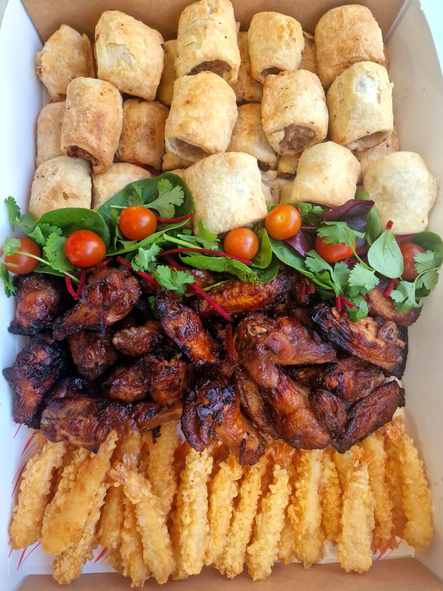 A platter of sausage rolls, glazed chicken wings, and tempura prawns