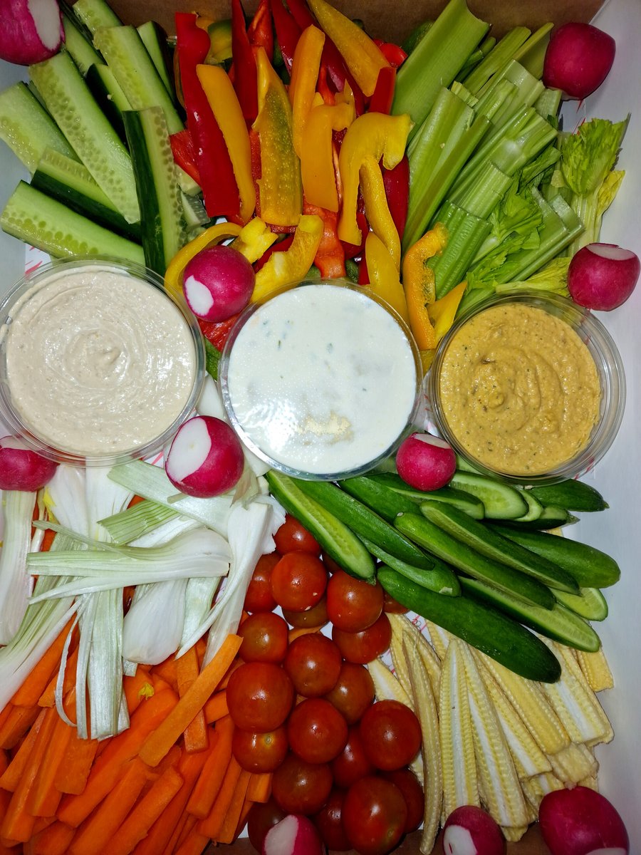 A platter of fresh, colourful crudités with three different dips