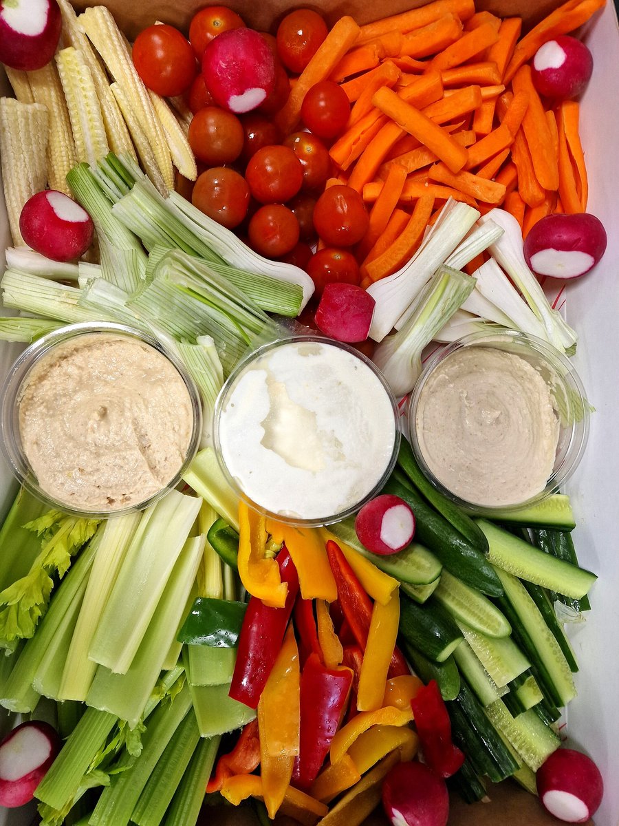 A platter of fresh crudités with three dips, beautifully arranged for catering