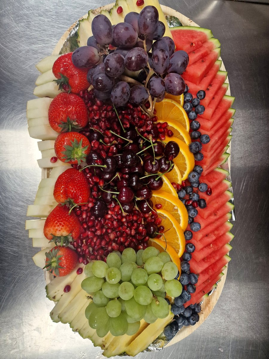 A vibrant and abundant fruit platter featuring a variety of fresh, colorful fruits
